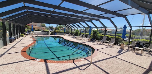 view of pool with glass enclosure and a patio area