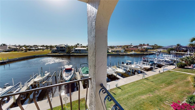 view of dock with a lawn and a water view