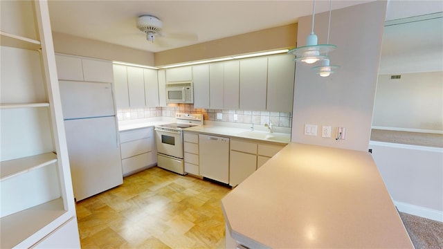 kitchen with pendant lighting, white cabinetry, sink, decorative backsplash, and white appliances