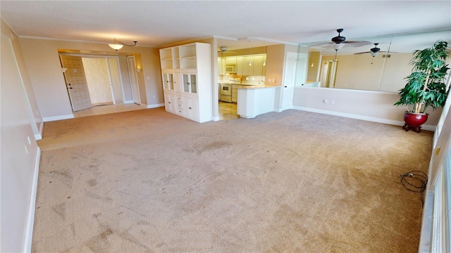 unfurnished living room with crown molding, light carpet, and ceiling fan