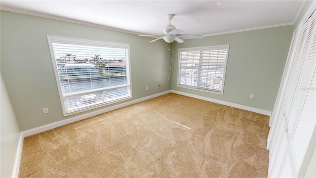 unfurnished bedroom with crown molding, light colored carpet, ceiling fan, and a closet