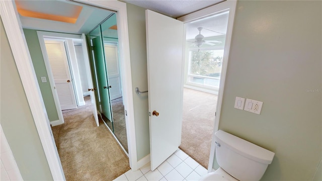 bathroom with ceiling fan, toilet, and tile patterned flooring