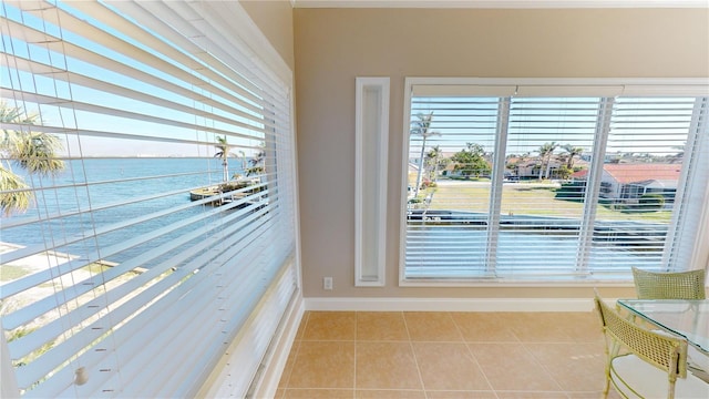 interior space featuring a water view, plenty of natural light, and light tile patterned floors