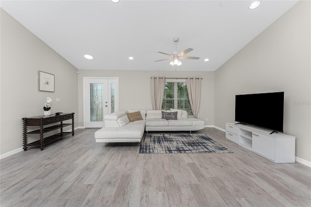 living room with light hardwood / wood-style floors, ceiling fan, and lofted ceiling