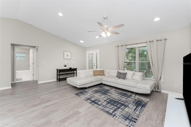 living room featuring ceiling fan, lofted ceiling, french doors, and light hardwood / wood-style flooring