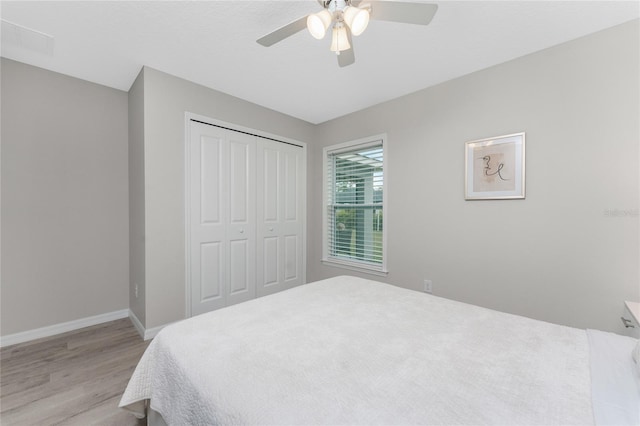 bedroom with ceiling fan, light hardwood / wood-style flooring, and a closet