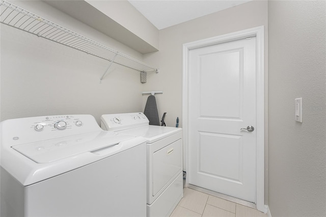 laundry room featuring light tile patterned flooring and separate washer and dryer