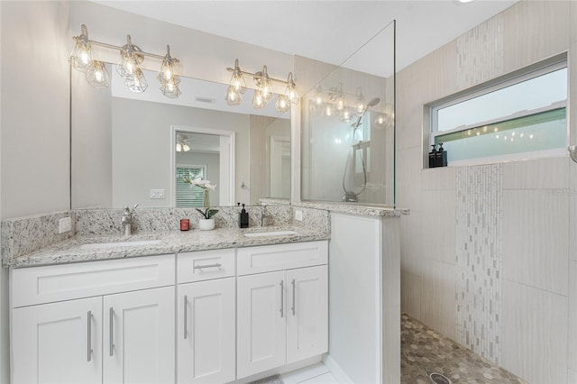 bathroom with vanity and tiled shower