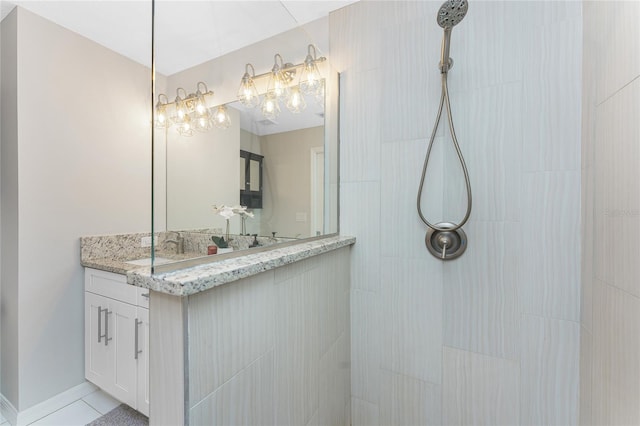 bathroom featuring tiled shower and vanity