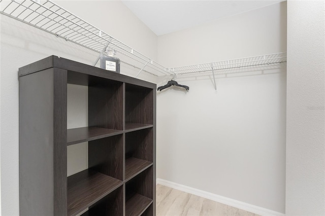 walk in closet with light hardwood / wood-style flooring