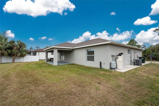 rear view of property with a lawn, a patio area, and central AC unit