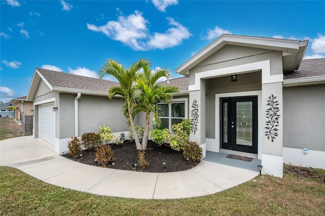 doorway to property with a lawn and a garage