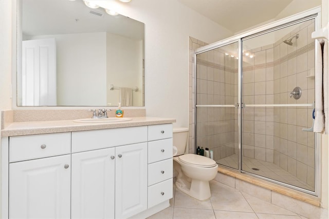 bathroom with tile patterned floors, vanity, toilet, and walk in shower