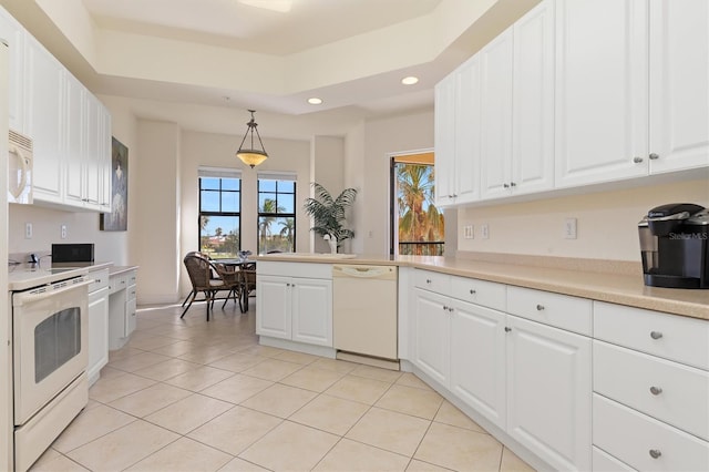 kitchen with hanging light fixtures, white cabinets, kitchen peninsula, white appliances, and light tile patterned flooring