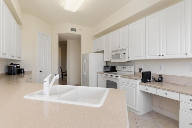 kitchen with sink, white cabinets, white appliances, and light tile patterned floors