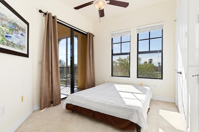 bedroom with multiple windows, access to outside, ceiling fan, and light colored carpet