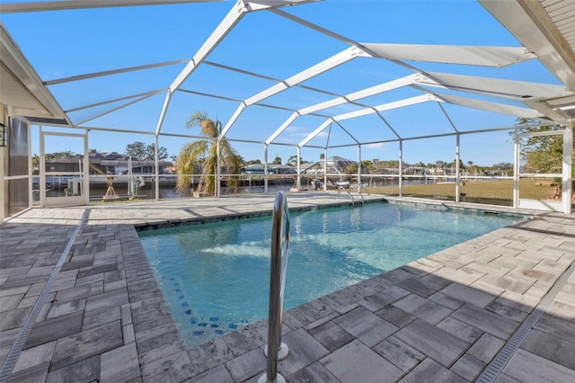 view of pool featuring a patio, a water view, and glass enclosure