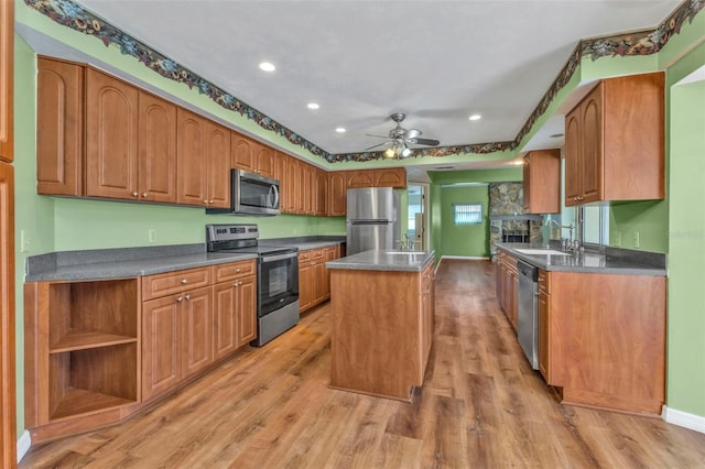 kitchen featuring sink, a center island, ceiling fan, stainless steel appliances, and hardwood / wood-style floors