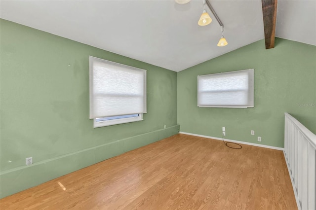 unfurnished bedroom featuring lofted ceiling with beams and light hardwood / wood-style flooring