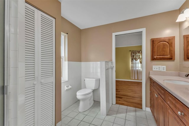 bathroom with vanity, tile walls, tile patterned floors, and toilet