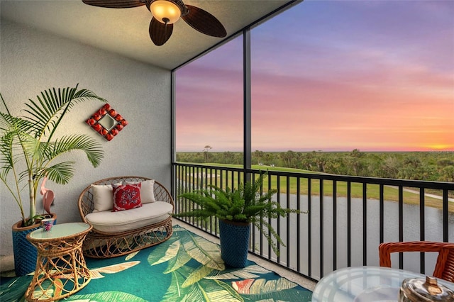 balcony at dusk featuring ceiling fan