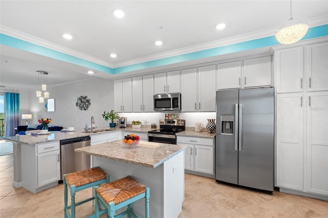 kitchen featuring sink, white cabinetry, hanging light fixtures, and appliances with stainless steel finishes