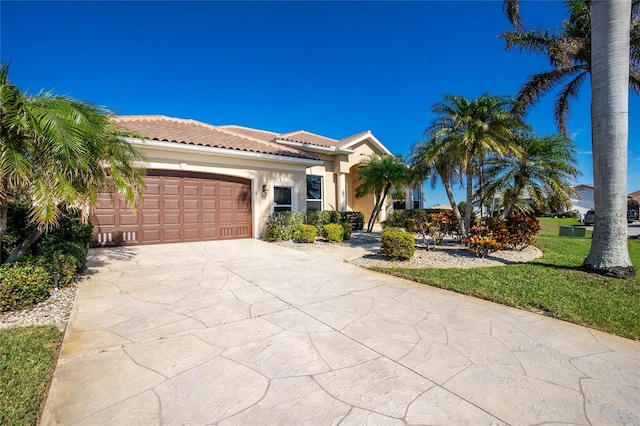 mediterranean / spanish-style house featuring a front yard and a garage