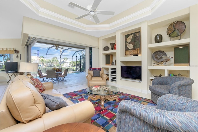 living room featuring tile patterned floors, built in shelves, a raised ceiling, and ornamental molding