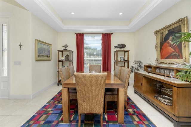 dining space with light tile patterned floors, a raised ceiling, and ornamental molding