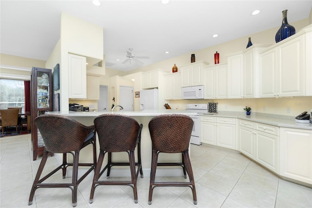 kitchen with white cabinetry, ceiling fan, an island with sink, white appliances, and light tile patterned floors