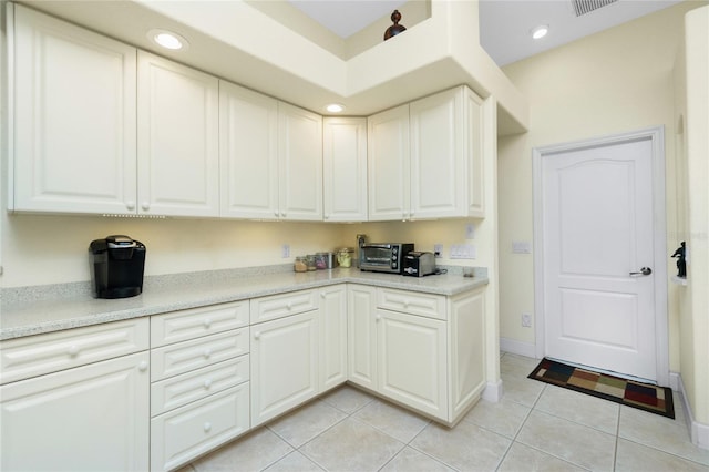 kitchen featuring white cabinetry and light tile patterned flooring