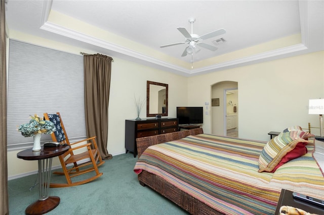 carpeted bedroom featuring a tray ceiling and ceiling fan