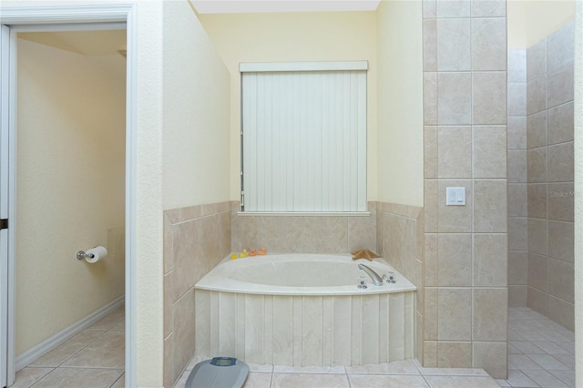 bathroom with tile patterned floors and a bath