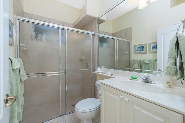 bathroom with tile patterned floors, vanity, toilet, and walk in shower