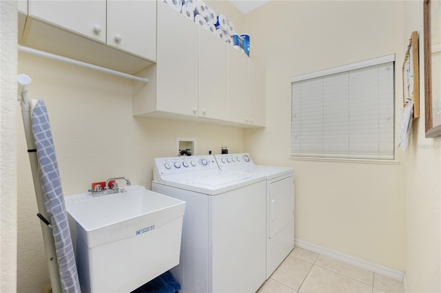 laundry room featuring washer and dryer, cabinets, light tile patterned floors, and sink