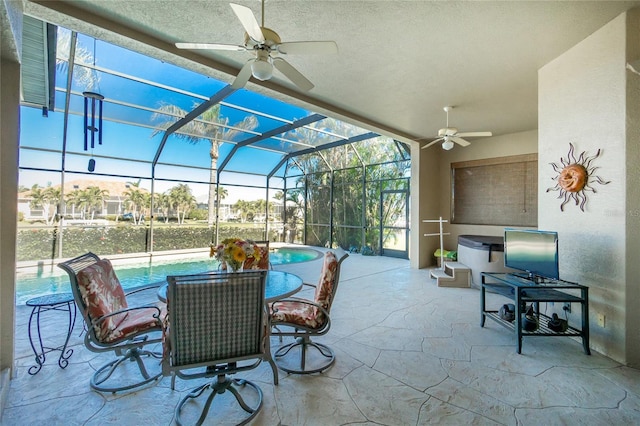 view of patio featuring ceiling fan and a lanai