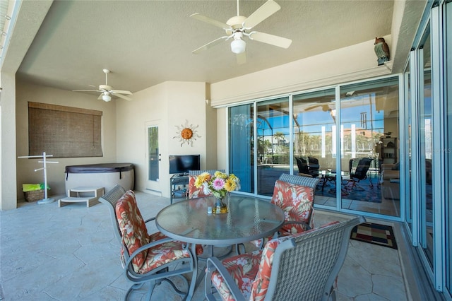 view of patio / terrace with ceiling fan and a hot tub