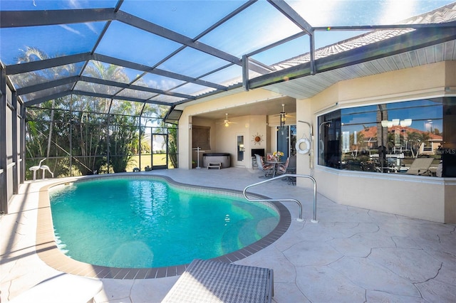 view of swimming pool with a patio, glass enclosure, and ceiling fan