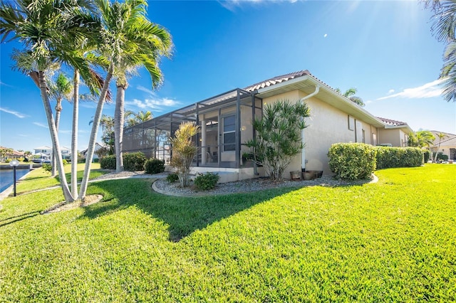 view of home's exterior with a lanai and a yard