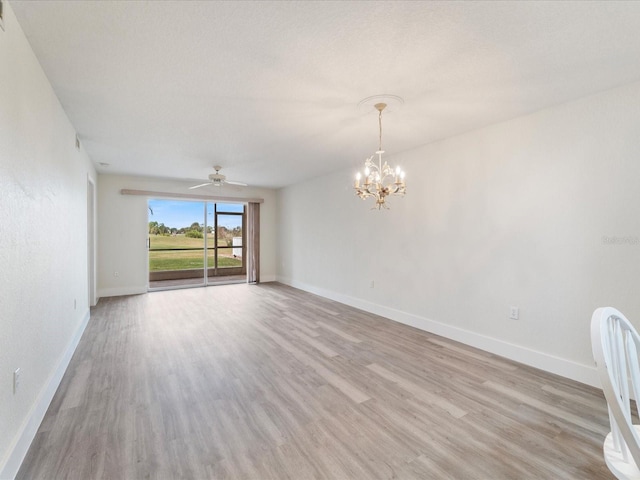 empty room featuring ceiling fan with notable chandelier and light hardwood / wood-style flooring