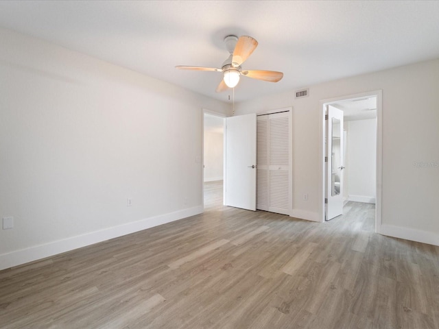 unfurnished bedroom with ceiling fan, light hardwood / wood-style flooring, and a closet