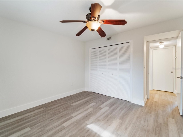 unfurnished bedroom with ceiling fan, light hardwood / wood-style flooring, and a closet