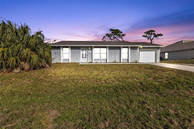 single story home with a lawn and a garage