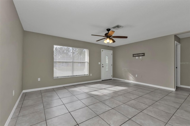 tiled spare room featuring ceiling fan