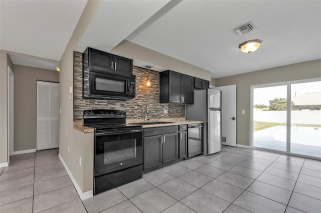 kitchen featuring light tile patterned floors, sink, light stone counters, and black appliances