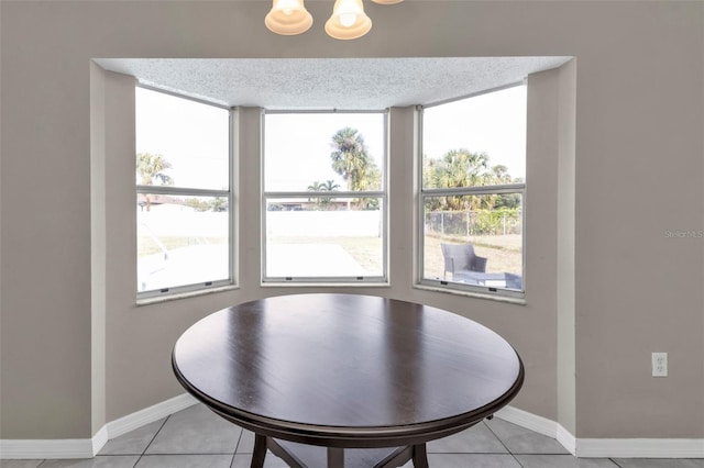 dining space featuring light tile patterned floors and a textured ceiling