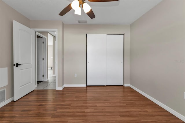 unfurnished bedroom with hardwood / wood-style flooring, ceiling fan, and a closet