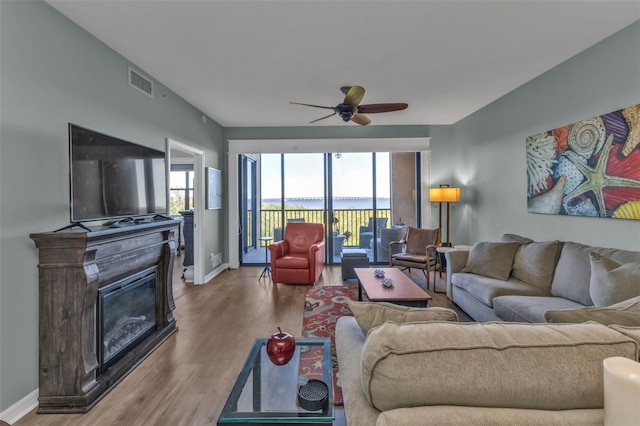 living room with ceiling fan, a healthy amount of sunlight, and light hardwood / wood-style flooring