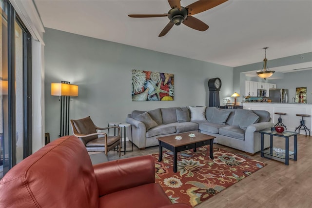 living room with ceiling fan and light hardwood / wood-style flooring