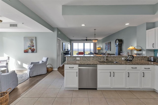 kitchen with white cabinetry, sink, stainless steel dishwasher, and dark stone counters